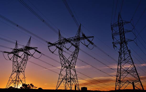 Sun setting below power lines